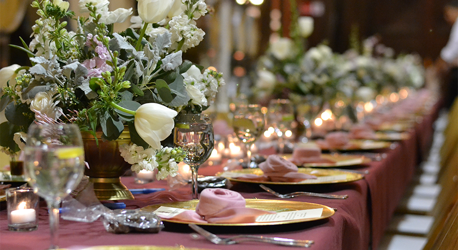 Valentine's Day table setting with elegant candles, plates, and fresh flowers